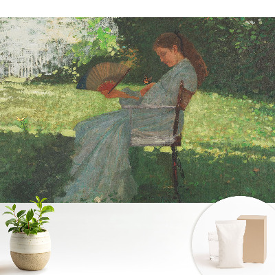 O femeie cu un ventilator în grădină simte armonie