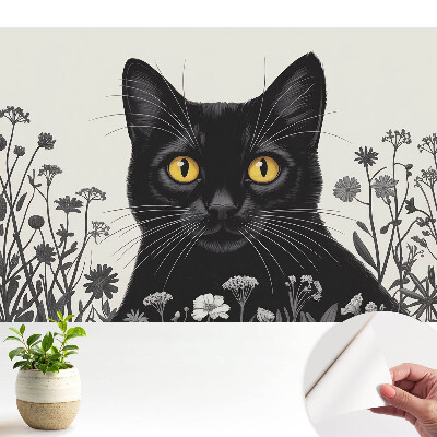 O pisică neagră cu ochi galbeni printre flori