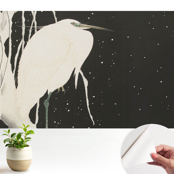 O pasăre pe o creangă într-o seară de iarnă