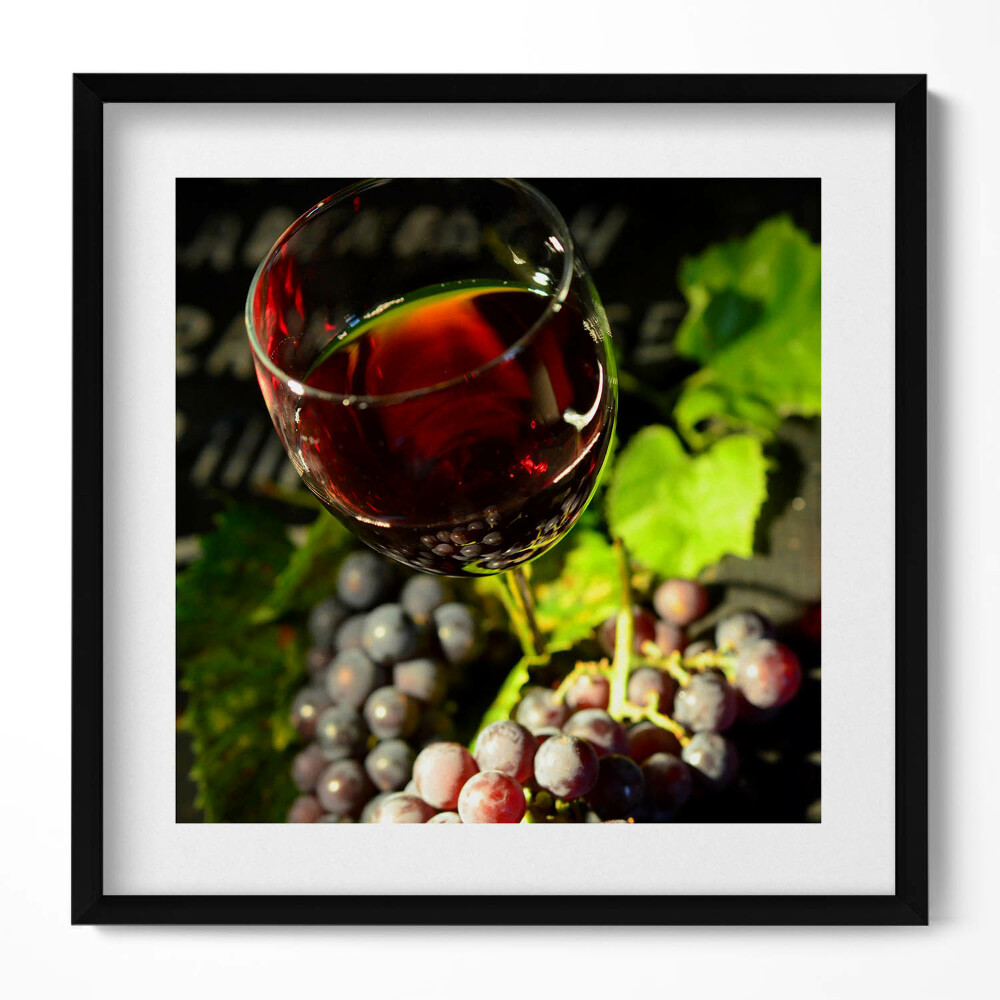 Tablou living cu rama unic Un pahar de vin roșu și struguri