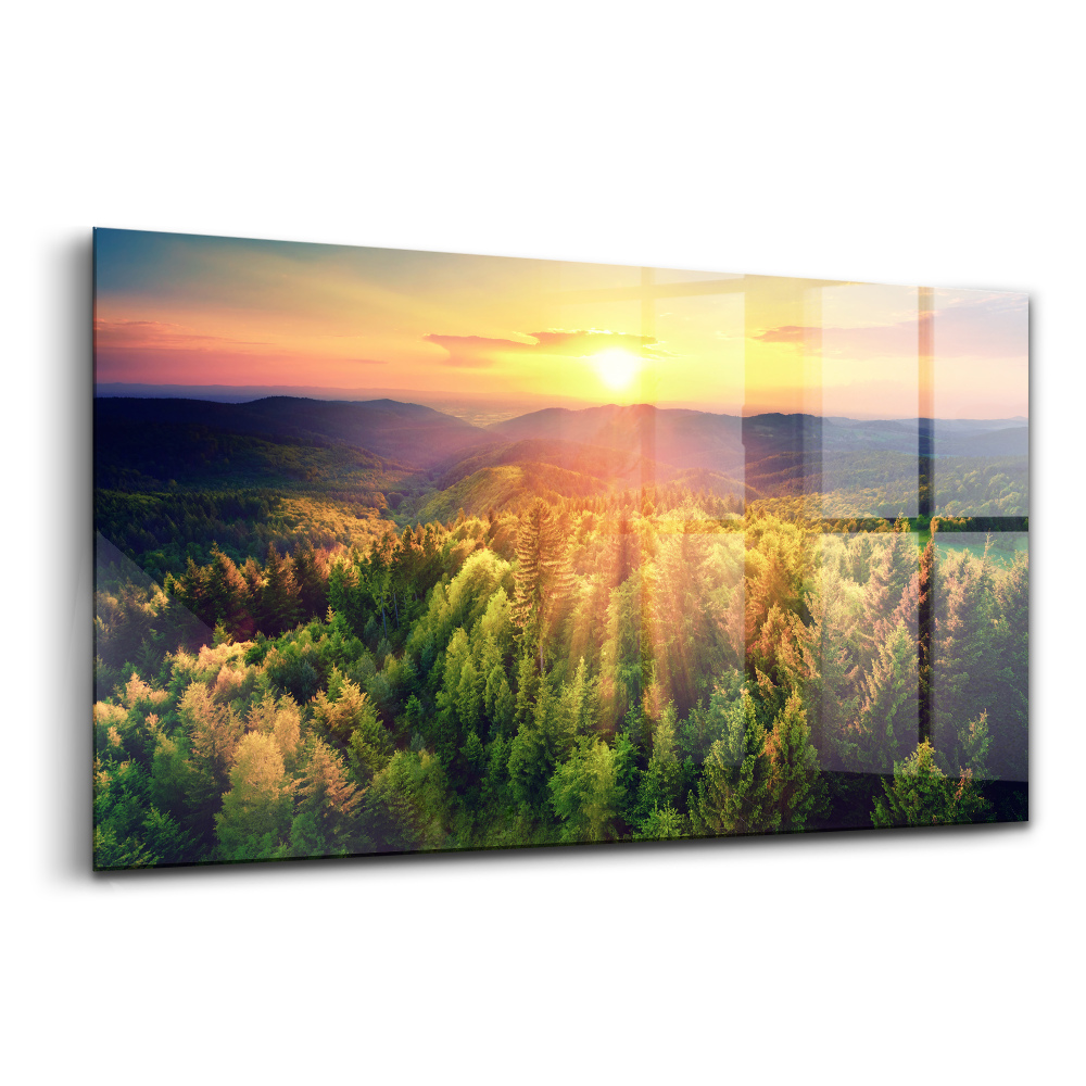 Tablou sticlă Apus de soare peste dealurile pădurii